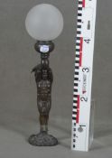 Tischlampe. Deutsch 20. Jh. Stehender, nackter Mann auf Sockel, am Kopf zwei Voluten mit Glaskugel,