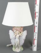 Tischlampe. Italien 20. Jh. Porzellan,  modelliert mit weiblicher Figur mit Schmetterlingsflügeln, 