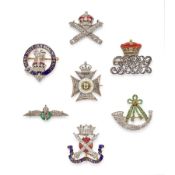 ENSEMBLE DE SEPT BROCHES RÉGIMENTAIRES EN OR, PLATINE, ARGENT, ÉMAIL, ÉMERAUDES, RUBIS ET