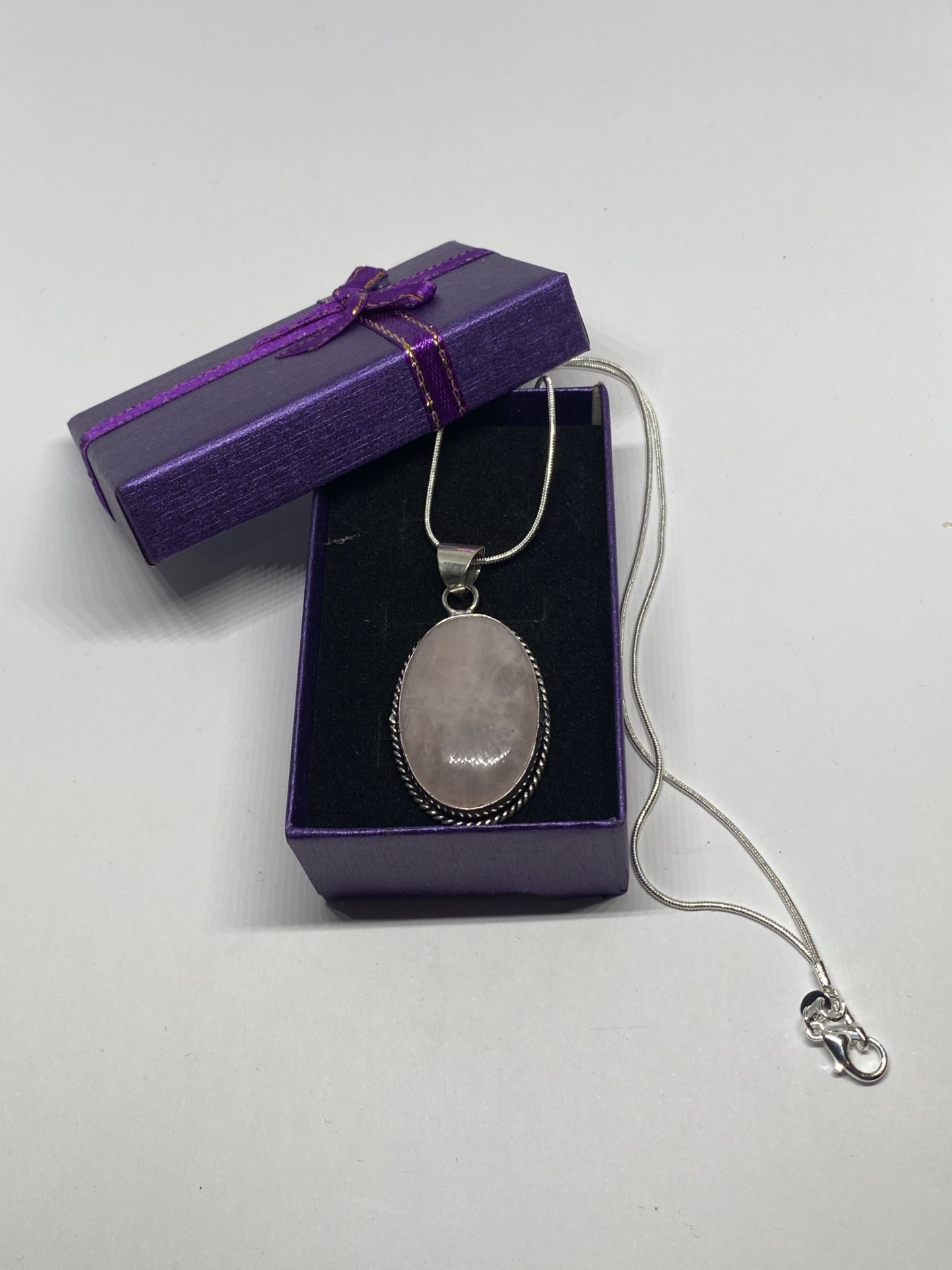 A MARKED 925 ROSE QUARTZ PENDANT ON A CHAIN IN A PRESENTATION BOX