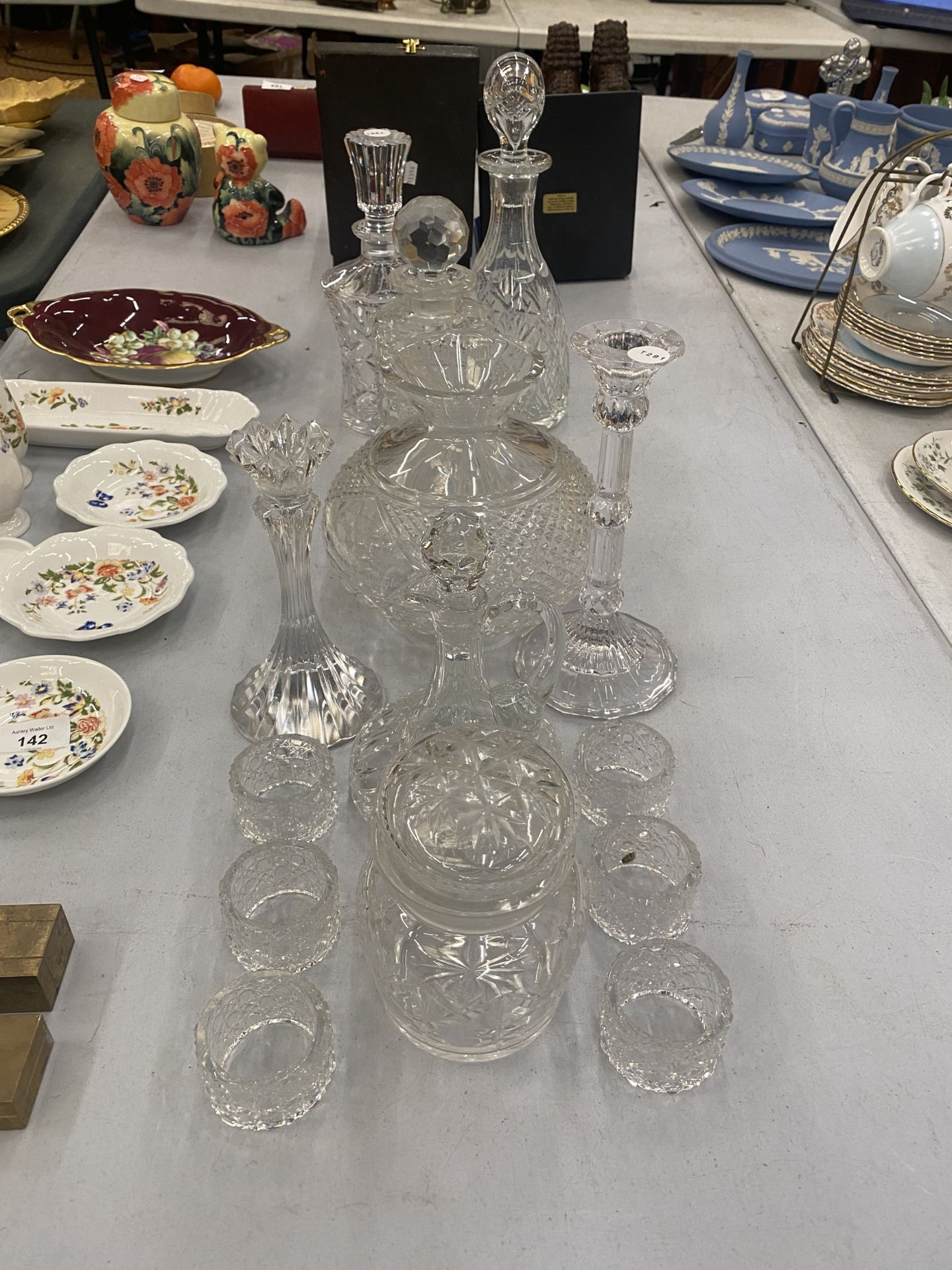 A LARGE ASSORTMENT OF CUT GLASS ITEMS TO INCLUDE DECANTERS, VASES, CANDLESTICKS ETC