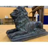A STONE DECORATIV SCULPTURE OF A RECLINING LION IN A VERDISGRIS COLOUR, HEIGHT 28CM, LENGTH 38CM