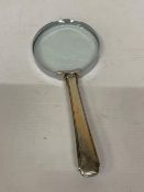 A VINTAGE MAGNIFYING GLASS WITH SILVER HANDLE