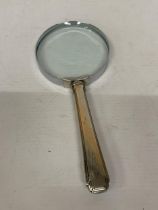 A VINTAGE MAGNIFYING GLASS WITH SILVER HANDLE