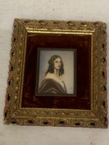 A VINTAGE HAND PAINTED PORTRAIT ON A CERAMIC PLAQUE, IN A GILT AND VELVET FRAME