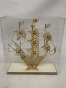 A MODEL OF A GILT GALLEON WITH ENAMEL FLAGS IN A CASE, HEIGHT 33CM, WIDTH 30CM, DEPTH 10CM