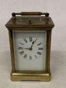 A FRENCH BRASS CARRIAGE CLOCK WITH GLASS ESCAPEMENT (ONE PANE MISSING)