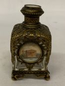 AN ANTIQUE FRENCH PALAIS ROYAL PERFUME BOTTLE WITH A CLEAR GLASS BODY ENCLOSED IN A PIERCED GILT-