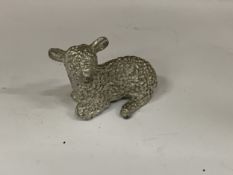 A SMALL WHITE METAL LAMB FIGURINE
