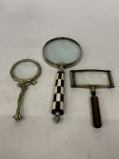 THREE VINTAGE MAGNIFYING GLASSES TO INCLUDE ONE WITH A BLACK AND WHITE CHECKERED HANDLE, BRASS