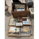 A WICKER BASKET WITH AN ASSORTMENT OF FRAMED PRINTS