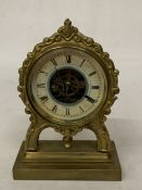 AN ORNATE BRASS MANTEL CLOCK WITH AN OPEN ESCAPEMENT MECHANISM ON ITS FACE