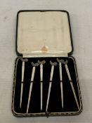 A CASED SET OF SIX ART DECO COCKTAIL STICKS WITH MOTHER OF PEARL SHAFTS AND CONTINENTAL SILVER