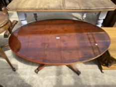 AN OVAL YEW WOOD PEDESTAL COFFEE TABLE