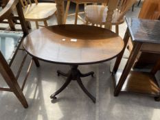 AN OVAL MAHOGANY AND CROSSBANDED PEDESTAL COFFEE TABLE
