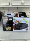 FOUR BOXED CAST IRON SIZZLE PLATTERS WITH WOODEN BASES AND HANDLES - NO VAT
