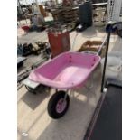 A PINK PLASTIC WHEEL BARROW
