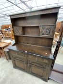 AN OAK DRESSER WITH PLATE RACK HAVING TWO GLAZED AND LEADED DOORS, 49" WIDE