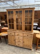 A PINE DRESSER WITH THREE DOOR GLAZED UPPER PORTION WITH FIVE DRAWERS AND TWO CUPBOARDS TO BASE, 50"