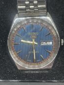A SEIKO 5 AUTOMATIC WRISTWATCH WITH BLUE FACE AND STAINLESS STEEL STRAP IN A PRESENTATION BOX SEEN