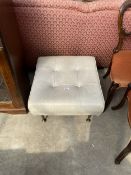 A RETRO CREAM FAUX LEATHER STOOL WITH BUTTONED TOP AND BRASS TAPERING LEGS