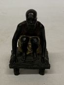 A BRONZE COLD PAINTED FIGURE OF A SQUATTING MAN, HEIGHT 11 CM