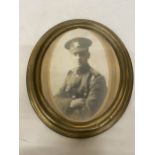 A PHOTO OF A WORLD WAR I SOLDIER IN AN A BRASS OVAL FRAME