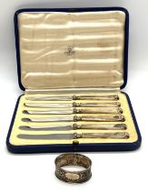 A cased set of silver handled knives along with a silver serviette ring