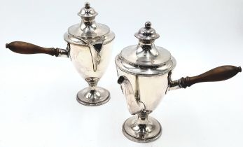A pair of silver-plated hot chocolate pots with fruitwood handles on pedestal bases
