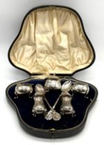 A cased silver five piece cruet set along with two hallmarked silver "Robin Hood Golf Club" spoons -