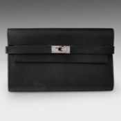 A Hermes Kelly wallet to go in black calfskin 11 x 20 cm. (4.33 x 7.87 in.)