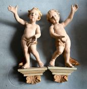 2 Holzfiguren „Putti“ wohl 18./19. Jh., polychrome Farbfassung