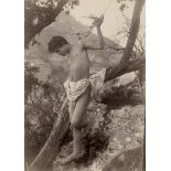 Gloeden, Wilhelm von: Young boy leaning on tree branch