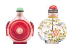 Two Chinese glass snuff bottles and stoppers one decorated in ruby overlay with roundels and mask