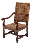A carved walnut and embroidered woolwork upholstered elbow chair in French 17th century style,