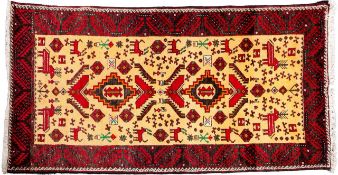 A Belouchistan rug, the ivory field with twin stepped medallions and stylised designs and animals,