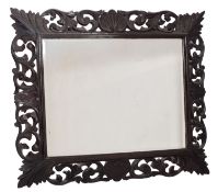 A carved and ebonised wood framed wall mirror in Bolognese early 18th century taste,