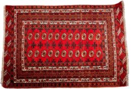 A Turkoman rug, the brick red field with two rows of quartered octagons,