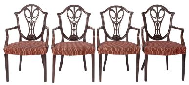 A set of four mahogany and upholstered elbow chairs in Hepplewhite style,