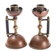 A pair of Arts & Crafts copper and brass candlesticks, after the design by Christopher Dresser,