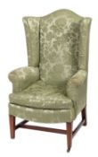 A Victorian upholstered wing armchair in George III taste,