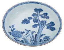 A large Chinese porcelain bowl, painted in blue with aged pine, bamboo and chrysanthemum, Qianlong,