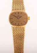 Omega De Ville a lady's 18K gold wristwatch with the gold cushion dial having raised baton numerals,