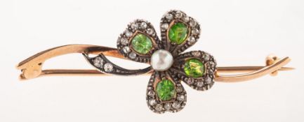 A Victorian green garnet, diamond and pearl Shamrock brooch, sat atop a curved bar,