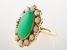 An opal and green stone cluster ring, collet set to the centre with an oval green stone cabochon,