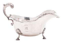 A George V silver sauce boat, shaped oval form, with a foliate scroll border,