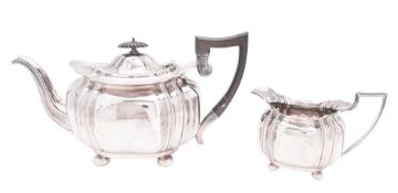 An Edwardian silver tea pot & matching milk jug, shaped oval form,