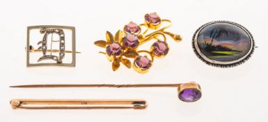 A stick pin and four brooches, the stickpin set atop with a collet set oval-cut amethyst,