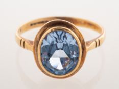 A 9ct gold dress ring, collet set with an oval-cut synthetic blue spinel, UK hallmark,