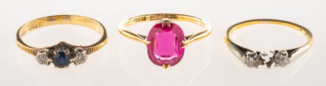 A group of three rings, including a ring claw set with an oval-cut red stone, approx 1.94 carats